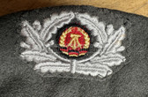 wo076 -  female Grenztruppen NVA Stasi beret with metallic badge - size 53