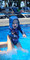 Baby wearing a Hooked Gear Snapper print fishing hoodie playing in a swimming pool