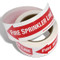 Photograph of the Fire Sprinkler Line Self-Adhesive Labels w/ Directional Arrows partially unraveled.