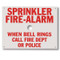 The sign is white with red lettering and reads "Sprinkler fire-alarm. When bell rings call fire dept or police."