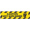 Photograph of an anti-slip floor safety sign reading "Caution Safety Gloves Required" in black on a yellow background.  Includes a graphic of black gloves.