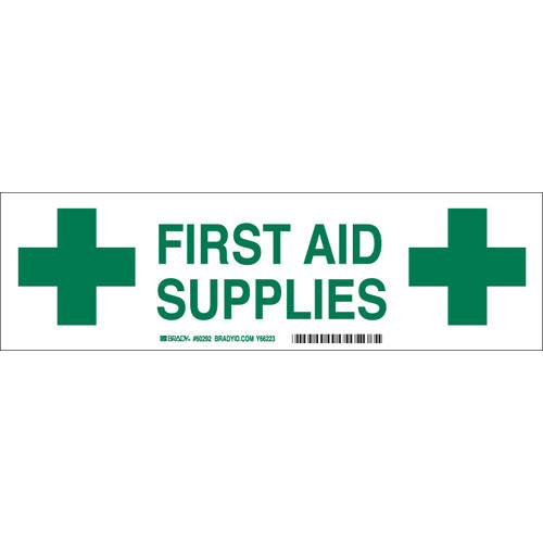 A green and white photograph of a 03416 first aid supplies cabinet label with cross graphics.