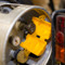 A photograph of a yellow 07001 zing recyclockout™ forklift propane tank lockout device open around propane tank valve.