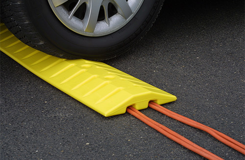 A photograph of a 02264 eagle speed bump/cable protector with a car on top of the bump.