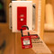 A photograph of a red 07156 zing recyclockout™ wall light switch lockout device installed on light switch in closed position with safety padlock.