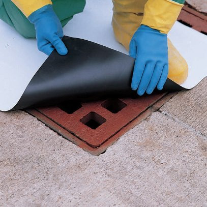 A photograph of a 04005 magnetic drain mat being installed over drain.