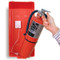 A photograph of a white 09350 fire extinguisher cabinet alarm installed on fire extinguisher and wall mount.
