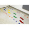 A photograph of dot/circle, arrow and foot markers in use on a floor.
