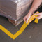 A photograph of yellow 06435 removable floor tape in use on floor at a facility.