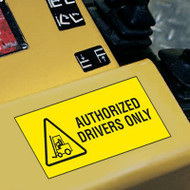 A photograph of a yellow 12207 forklift label, reading authorized drivers only with graphic installed on machinery.