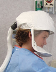 A photograph of a female wearing a  Bullard EVA20LF2 powered air-purifying respirator, with loose-fitting facepiece.