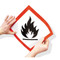 Photograph of GHS flame pictogram label being applied to surface.