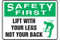 A photograph of a green and white 12308 safety first, lift with your legs not your back sign with icon.