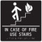 A photograph of a white on black 03503 ADA braille tactile sign, reading in case of fire use stairs with person on stairs icon.