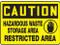 A photograph of a yellow and black 01552 caution hazardous waste storage area Restricted Area OSHA sign.