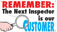Picture of Workplace Safety Banner that features a clean white background. In the bottom left is a hand holding a magnifying glass up to the text on the banner. Along the top of banner in bold eye-catching red it reads "Remember:", continued below in bold black text it reads "The next inspector is our", and finished off in cool blue text it reads "Customer". The text combined reads out "Remember: the next inspector is our customer"