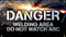 Picture of Workplace Safety Banner that features  a dark background lit up by sparks, as something is being welded in the background. In front of this in clear large bold white letters the banner reads "Danger". Below in slightly smaller white text it reads "Welding area do not watch arc".