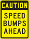A photograph of a yellow and black 06252 speed bump sign, reading caution speed bumps ahead.