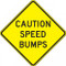 A photograph of a yellow and black 06257 speed bump sign, reading caution speed bumps.