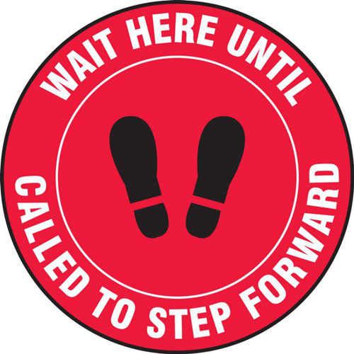 A photograph of a red and white 11229 social distance floor sign, reading wait here until called to step forward, with footprints icon.