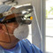 Person wearing the face shield with dental loupes and N95 facemask; side view.