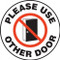 A photograph of a white and black 11257 pavement print sign, reading please use other door, with door graphic.