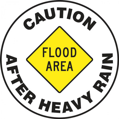 This sign features a yellow caution sign in the center reading "Flood Area", and text around the border reading "Caution After Heavy Rain".