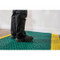 Photograph of a NoTrax Interlocking Drainage Mat 524 with a person standing on it.