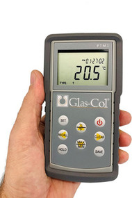 A photograph of a 20075 battery operated handheld digital thermometer for type k, j and t thermocouples in a person's hand.