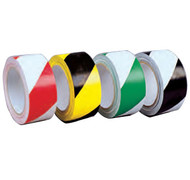 A photograph of a four roles of 06361 striped hazard warning conformable tape.  From left to right: red/white, yellow/black, green/white, black/white.