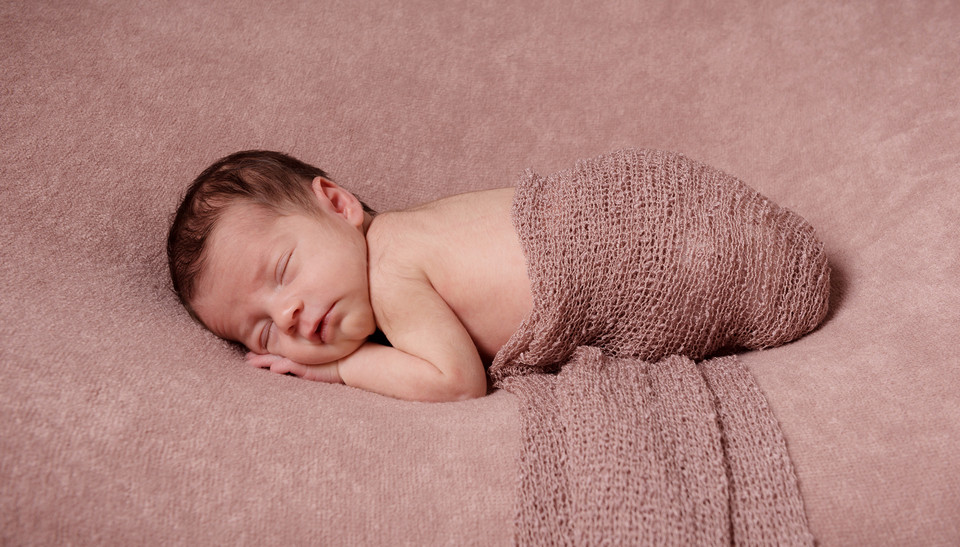 photograph of newborn baby wrapped coloured fabric