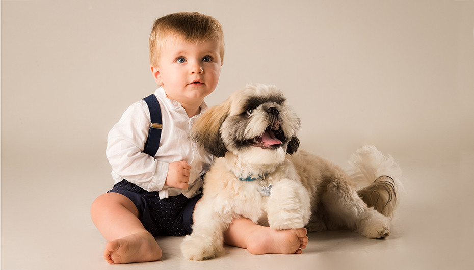 Image of a child cuddling with pet dog, photographed by Emotion Studios. 