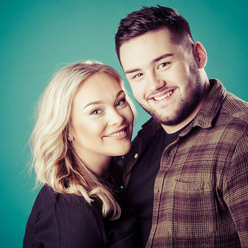 Photograph of young couple together in front of green background. Image by Emotion Studios photography. Photograph of young couple together in front of green background. Image by Emotion Studios photography.