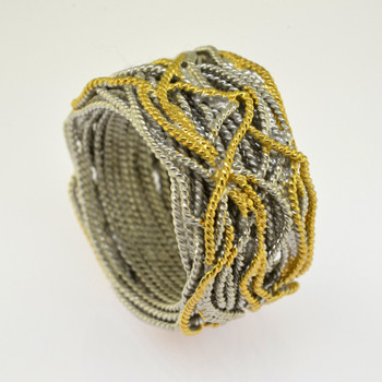 A very comfy, very stylish ring, woven in twisted Sterling Silver wire, and highlighted with 14 karat Yellow Gold electroplate. Measures 3/4 inch wide.

Standard size 7 1/2, or let us know what size you need. This ring is a special order item, please allow 4-6 weeks to arrive from Spain.

Handcrafted in Northern Spain.