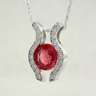 You will be captivated by this modern, elegant 14 karat White Gold Sapphire and diamond pendant. Yes, we said Sapphire. They do come in every color, and this 1.36ct. bright cinnamon orange Sapphire is a fine example of the orange variety. Framed with .33ct. T.W. of Ideal cut Diamonds, and includes a 1mm 14 karat White Gold anchor chain, 16 inches long.

Designed, and created in our studio by the artist Stuart J.