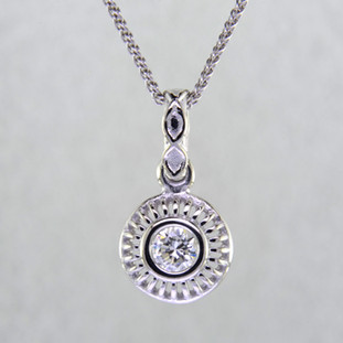 Blending traditional and modern for a timeless look, this diamond pendant dazzles day and night. Made in 14 karat White Gold, with a scintillating .24ct. Ideal cut Diamond. This beautiful diamond pendant hangs on a 14 karat White Gold 1.3mm cable chain, 18 inches long. Pendant measures 5/8 inch long.  

Designed, and created in our studio by the artist Stuart J.