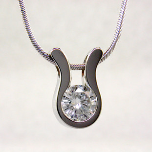 An elegant, modern shape makes this pendant a go-to for every occasion. 14 karat White Gold with a .22ct. (G SI2 Quality) Ideal cut Diamond, this pendant has a classic, timeless style. Includes a 14 karat White Gold 1mm cable chain, 18 inches long. Pendant measures 1/4 inch long.  

Designed, and created in our studio by the artist Stuart J.