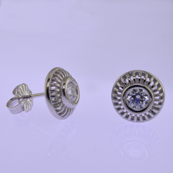 Blending traditional and modern, these diamond earrings are the perfect accessory for day or night. These stylish studs are made in 14 karat White Gold, with .48ct. T.W. of round Ideal cut Diamonds set in bezels, with posts. Earrings measure 1/4 inch in diameter.

Designed, and created in our studio by the artist Stuart J.