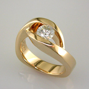 This elegant engagement ring has a low profile, and is easy to wear. Priced here in 14 karat gold for a 1/2ct. center (We can make it in any metal, and for any size diamond or colored gemstone). This is truly a timeless design, with no prongs to catch. Matching shadow wedding band is also available.

This custom designed engagement ring is individually crafted to be Perfectly You, and takes about 2 weeks to create. Call us for more information about how we can customize this design Just For You. Designed, and created in our studio by the artist Stuart J.