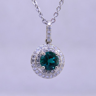 Elegant and timeless double halo pendant, in 14 karat white gold with .33ct. T.W. of Ideal cut diamonds, and an incredible 6.5mm deep green, brilliant cut Chatham Created Emerald. Includes a 1.3mm diameter 14 karat white gold wheat chain, 18 inches long.

Designed, and created in our studio by the artist Stuart J.

Chatham® Created Gemstones are grown in carefully controlled laboratory conditions. They are chemically and optically identical to their natural counterparts, yet cost much less. Because the environment in which they are grown is controlled, the imperfections often found in natural gemstones, are absent in Chatham® Created Gemstones. Because of this, and superior cutting, Chatham® gems exhibit the color and sparkle of the finest natural gems. Each one comes with a Certificate of Authenticity, and a Lifetime Warranty.