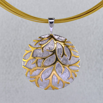 Gold branches stand out against a wintery white background in this nature inspired Sterling Silver pendant. Hanging on a 12 strand gold plated stainless steel wire necklace, 16 inches long. The pendant measures 1 1/4 inches around, for a distinctive look.

Handcrafted in Northern Spain.