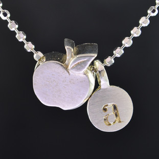 What's your story? Begin with this Little Apple solid Sterling Silver charm. Wear it alone, with other charms (such as the Mini "a" shown, and sold separately), or layered with other necklaces. Comes with a sterling silver ball chain, 16 inches long. The charm measures 1/4 inch long. Too cute!

Signified by a feminine sensibility and optimistic charm, Alex Woo's Little Icon Collections reinvent familiar symbols from the world around us into fresh and expressive designs.

Designed and handcrafted by Alex Woo in New York City.