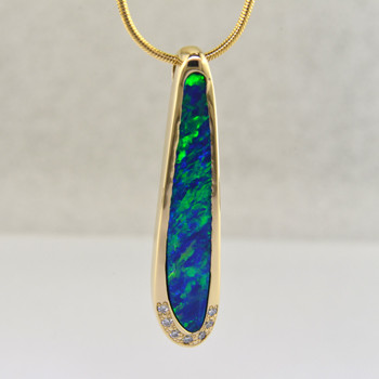 This dreamy pendant was designed and handmade for this special one-of-a-kind opal - a deep, rich blue-green 3.66ct. Andamooka Opal doublet. Crafted in 14 karat yellow gold, it is accented with a sprinkling of .06ct. T.W. of Ideal cut Diamonds. Includes a 14 karat yellow gold, 1mm silky smooth snake chain, 18 inches long. Pendant measures 1 1/2 inches long.

Designed, and created in our studio by the artist Stuart J.

Our Andamooka opals are cut exclusively for us, and come directly from the mine in Andamooka, Australia. Our opal doublets are two layers, the top is the color layer, and the bottom is the opal host rock, or matrix. These layers are bonded together to make a stronger, more durable opal, and are guaranteed not to come apart or craze.