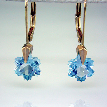 What's better than one sparkling snowflake? Two, of course. One for each ear. And you can turn up the heat, because these snowflakes won't melt. Exclusively ours, each blue topaz snowflake is custom cut just for us, in Canada, by master gem cutters. Each snowflake measures 8mm, and dangles in a 14 karat white gold Piercette® setting on a lever back, measuring 1 inch long.
Designed and handmade by the artist Stuart J.

A Piercette® is a patented method of setting, with a gemstone that moves. The gem is set so that it swivels with every movement of the wearer, exhibiting extra sparkle.