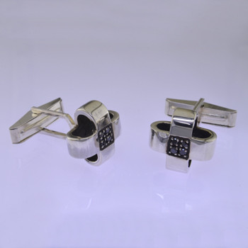 Black diamond cuff links for the sophistcated man. Handcrafted in solid Sterling Silver, with contrasting black diamonds for a modern feel. Measures 5/8" long and 5/8" wide.

by David Heston of San Rafael, California.
