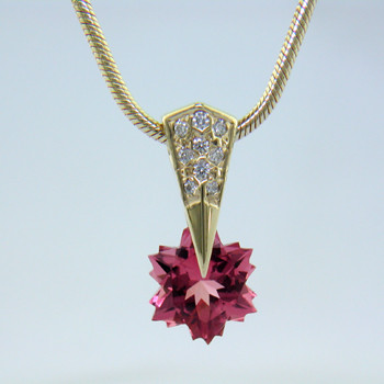 Our fabulous, exclusive, patented, one-of-a-kind Piercette® pendant, set with .09ct. of Ideal cut, pave set diamonds, and a custom cut snowflake Pink Tourmaline. Measuring 8mm, this vibrant pink tourmaline has been expertly cut, just for us, in Canada, by third generation gem cutters. Includes a 14 karat yellow gold, 1.3mm diameter smooth snake chain, 16 inches long. Pendant measures 5/8" long.
Designed and handmade by the artist Stuart J.

A Piercette® is a patented method of setting, with a gemstone that moves. The gem is set so that it swivels with every movement of the wearer, exhibiting extra sparkle.