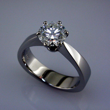 Simple and elegant solitare engagement ring. When you are not sure what style she likes, keep it simple, not plain. Extra wide on the bottom for the ultimate in comfort, and so it does not spin on the finger. 

This elegant engagement ring is priced in 14k gold, and can be made in any karat or color of gold, and in platinum. This one is made for a 1/2 carat center (priced seperately), but we can make it for any size diamond. A matching fitted wedding band is also available.

This custom designed engagement ring is individually crafted to be Perfectly You, and takes about 1 to 2 weeks to create. Call us for more information about how we can customize this design Just For You. Designed, and created in our studio by the artist Stuart J.