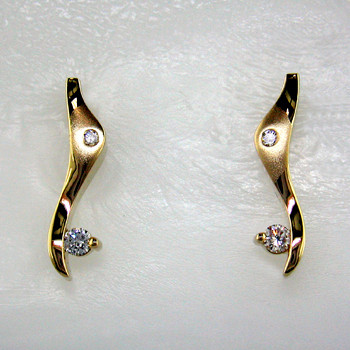 Striking, modern diamond earrings in 14 karat yellow gold with .20ct. T.W. of ideal cut diamonds, with posts.  These elegant diamond earrings measure 3/4". 

Designed, and created in our studio by the artist Stuart J.