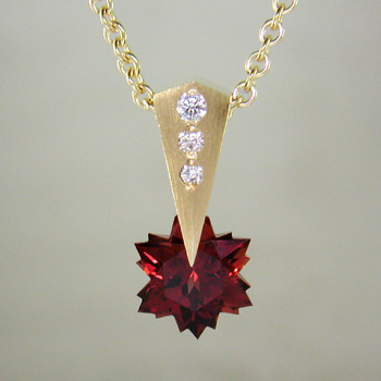 This Garnet snowflake and Diamond Piercette® pendant will melt your heart. Dangling in 14 karat yellow gold, with an 8mm custom cut deep red Garnet snowflake and sprinkled with .07ct. T.W. Ideal cut Diamonds.

The Garnet snowflake gemstone is custom cut, exclusively for us, in Canada. Includes a 14 karat yellow gold 1.2mm diamond cut rope chain, 16 inches long. Pendant measures 5/8" long.

Designed and handmade by the artist Stuart J.

A Piercette® is a patented method of setting, with a gemstone that moves. The gem is set so that it swivels with every movement of the wearer, exhibiting extra sparkle. 