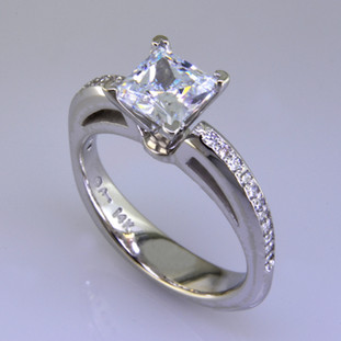 This beautiful diamond engagement ring design with its simple, clean lines frames your diamond perfectly. The bottom has soft rounded corners for the ultimate comfort. This is a contemporary, but timeless design.  

This elegant diamond engagement ring is priced in 14k white gold, and can be made in any karat or color of gold, and in platinum. Set with .17ct. of ideal cut diamonds, this one is shown with a 1 carat princess cut center (sold seperately), but we will make it for any size. A matching shadow wedding ring or a diamond wedding ring is available.

This custom designed engagement ring is individually crafted to be Perfectly You, and takes about 2 weeks to create. Call us for more information about how we can customize this design Just For You. Designed, and created in our studio by the artist Stuart J.